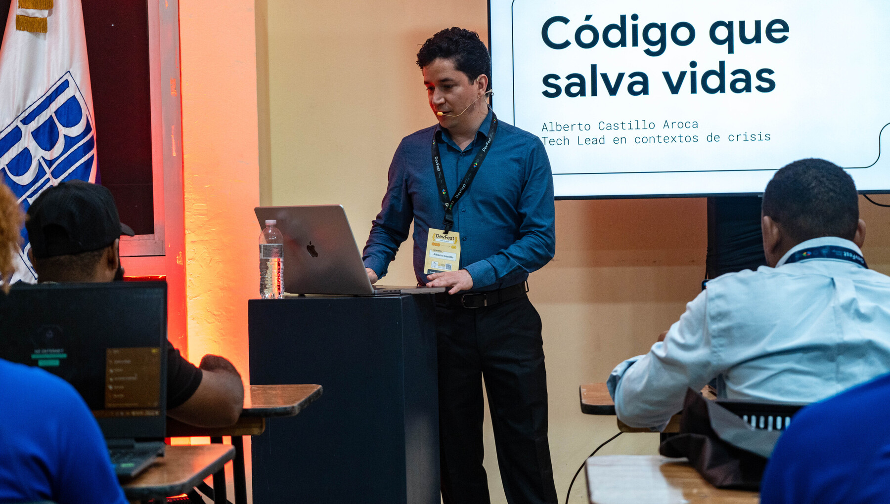 Alberto Castillo Aroca ante la lámina de título de su conferencia «Código que salva vidas», con el público del DevFest Santo Domingo 2026 en primer plano